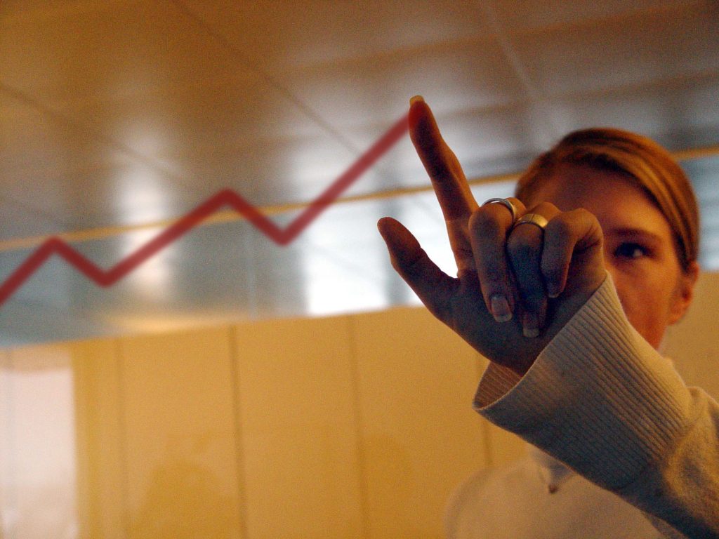 Photo of a woman pointing to increased projections.